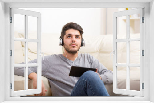 Handsome casual young man using a tablet at home