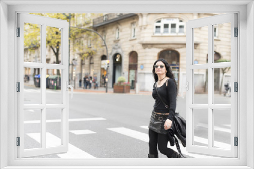 Woman with sunglasses heavy metal style walking in the street.