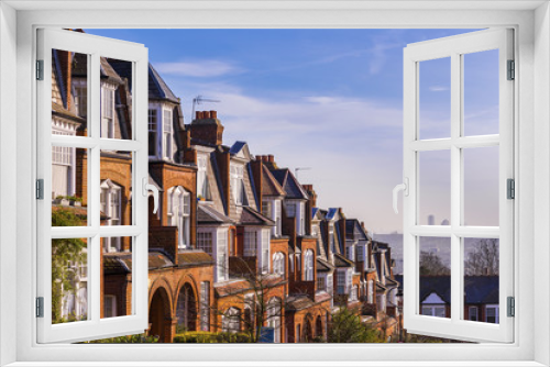 Fototapeta Naklejka Na Ścianę Okno 3D - London, United Kingdom - Traditional British brick houses at Muswell Hill on a panoramic shot early in the morning with blue sky