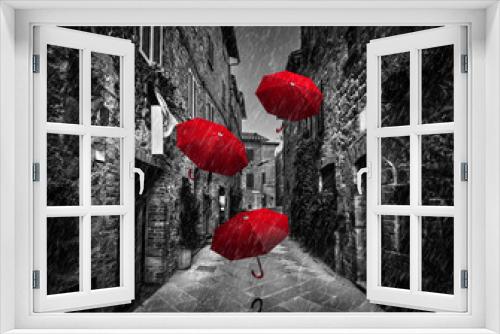 Fototapeta Naklejka Na Ścianę Okno 3D - Umrbellas flying with wind and rain on dark street in an old Italian town in Tuscany, Italy