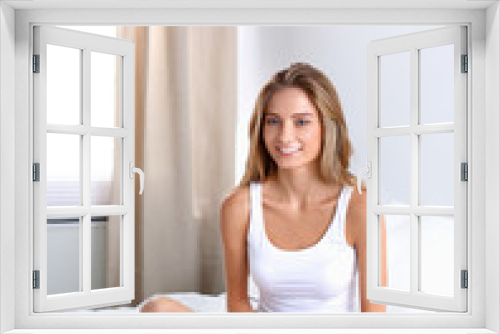 Beautiful woman drinking a coffee sitting on her bed at home