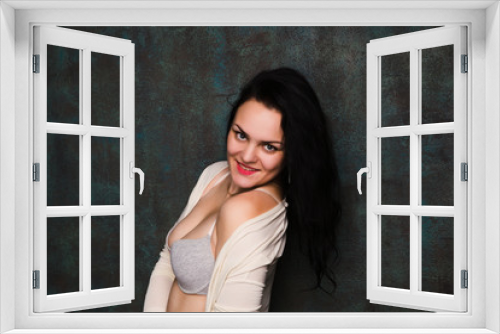 Studio portrait of a sexy brunette in grey lingerie and white cardigan