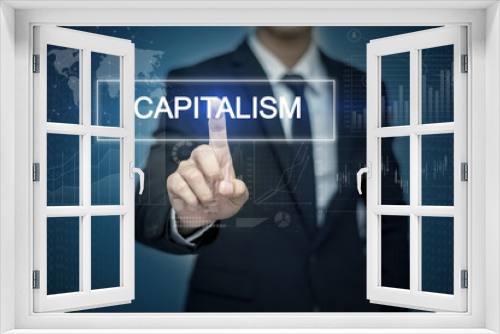 Businessman hand touching CAPITALISM   button on virtual screen