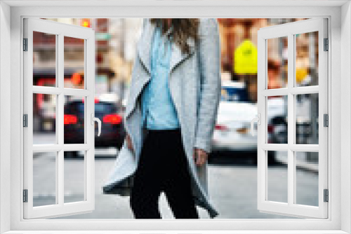 Full length portrait of beautiful smiling woman walking on city street