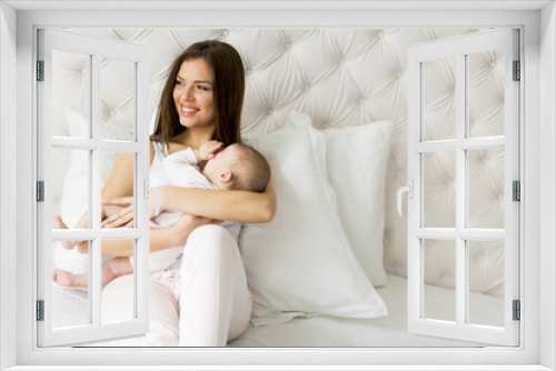 Happy mother with baby on bed