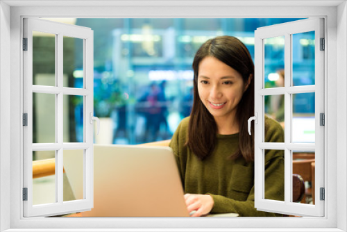 Woman working on notebook computer at cafe