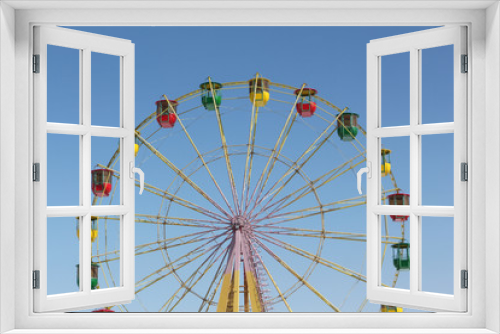 Fototapeta Naklejka Na Ścianę Okno 3D - Ferris wheel with color cabins against the blue sky