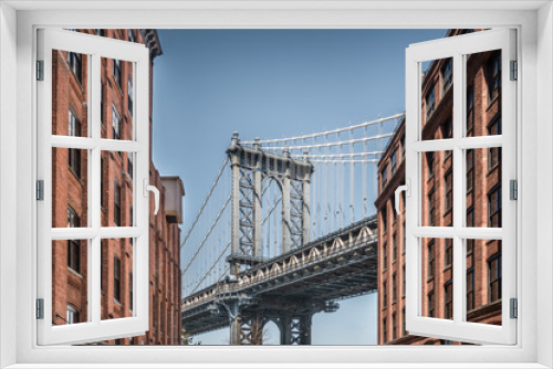 Fototapeta Naklejka Na Ścianę Okno 3D - Manhattan bridge seen from narrow buildings on a sunny day