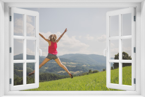 Fototapeta Naklejka Na Ścianę Okno 3D - Girl jumping in a field.