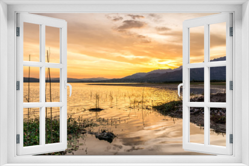Fototapeta Naklejka Na Ścianę Okno 3D - Colorful sunset reflected in the lake with the mountains at the background