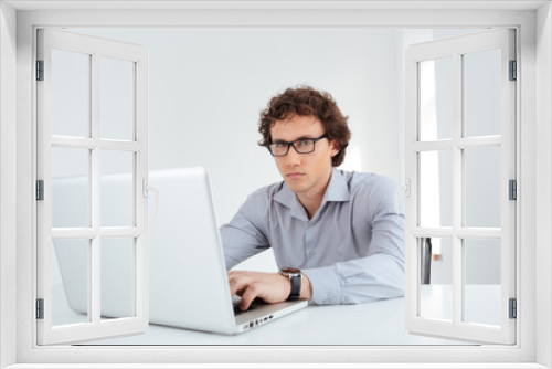 Businessman in glasses working on laptop computer