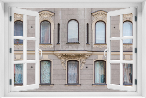 Several windows in a row and bay window on facade of urban apartment building front view, St. Petersburg, Russia.