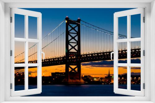 Fototapeta Naklejka Na Ścianę Okno 3D - A Sunset View of  The Benjamin Franklin Bridge, Philadelphia, Pennsylvania from the Delaware River.