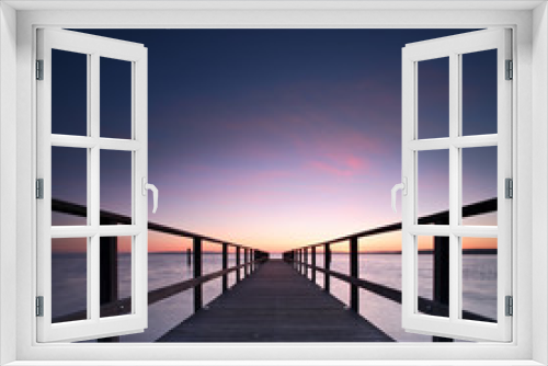 Fototapeta Naklejka Na Ścianę Okno 3D - Long Wooden Pier into a Lake at Sunset, perfect symmetry