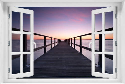 Fototapeta Naklejka Na Ścianę Okno 3D - Long Wooden Pier into a Lake at Sunset, perfect symmetry