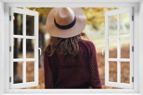 Fototapeta Naklejka Na Ścianę Okno 3D - Rear view of brunette girl in autumn/fall park in brown hat, swe