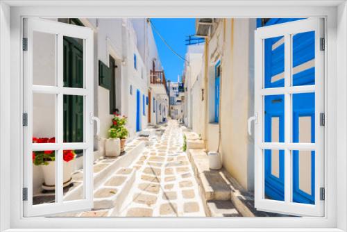 Fototapeta Naklejka Na Ścianę Okno 3D - Typical white Greek houses with blue doors and windows on street of beautiful Mykonos town, Cyclades islands, Greece
