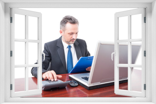 Man at office holding clipboard and calculating