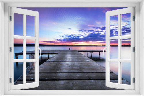 Fototapeta Naklejka Na Ścianę Okno 3D - Wooden pier on a blue lake sunset and smooth reflection on water