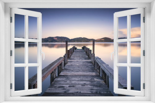 Fototapeta Naklejka Na Ścianę Okno 3D - Wooden pier or jetty on a blue lake sunset and sky reflection on