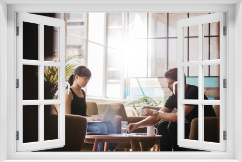 Two businesspeople meeting in lobby area of modern office