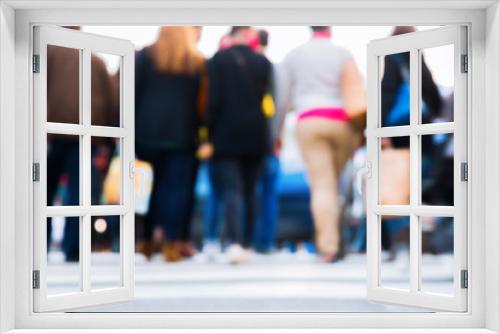 out of focus picture of people crossing a street