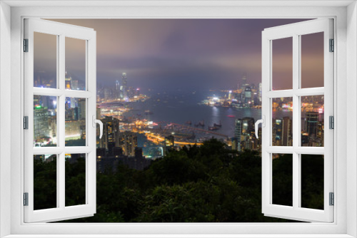 Fototapeta Naklejka Na Ścianę Okno 3D - Lit skyscrapers and other buildings on Hong Kong Island and Kowloon in Hong Kong, China. Viewed from the Braemar Hill on a foggy and cloudy evening. 