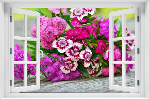 Fototapeta Naklejka Na Ścianę Okno 3D - Bouquet of small carnations on a wooden background