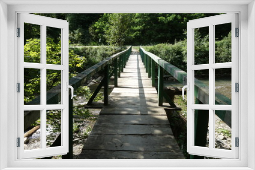 Fototapeta Naklejka Na Ścianę Okno 3D - Wooden bridge over mountain river. Transcarpathia