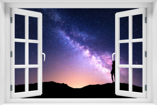 Fototapeta Naklejka Na Ścianę Okno 3D - Beautiful purple Milky Way with standing woman. Colorful landscape with night sky with stars and silhouette of a girl on mountain on the background of beautiful galaxy. Milky way with yellow light.