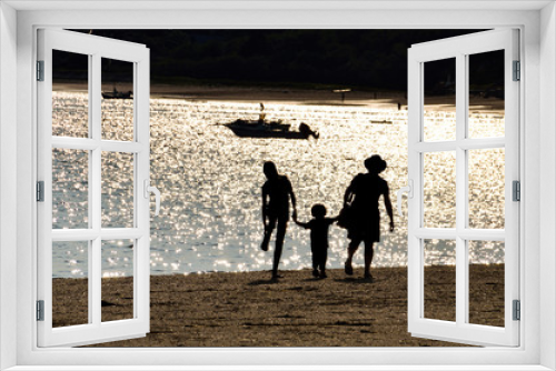 Fototapeta Naklejka Na Ścianę Okno 3D - Silhouette of three people family holding hands walking on beach in cape cod during sunset