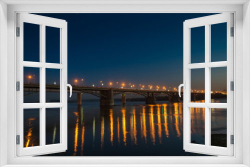 Fototapeta Naklejka Na Ścianę Okno 3D - Bridge with bright lights across the river at night and reflecti