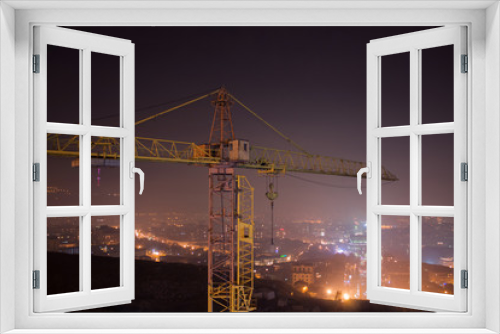 Fototapeta Naklejka Na Ścianę Okno 3D - a night landscape hoisting crane and city