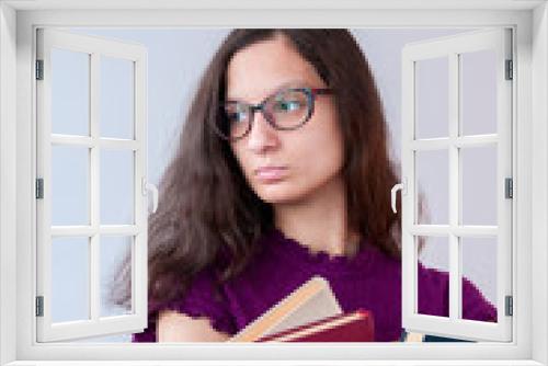 Girl student in glasses with books looking away 