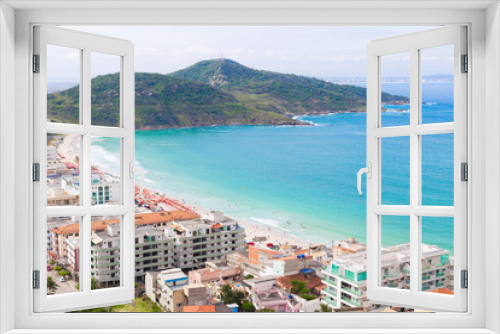 Fototapeta Naklejka Na Ścianę Okno 3D - Coastline over paradise beach destination. Hotels, beach umbrellas, and mountains in the background. The water is refreshingly turquoise. Praia dos Anjos in small town Arraial do Cabo in Brazil
