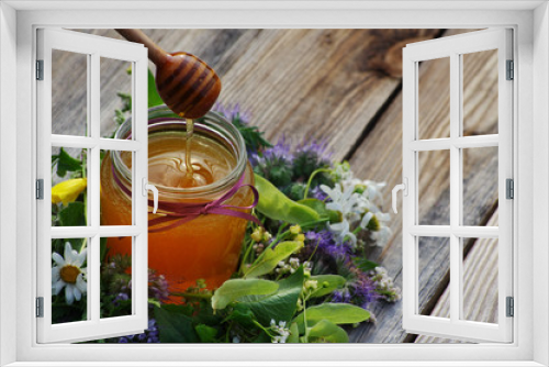 Fototapeta Naklejka Na Ścianę Okno 3D - Honey in a glass jar with flowers melliferous herbs on a wooden surface. Honey with flowers.