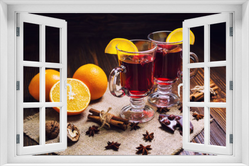Fototapeta Naklejka Na Ścianę Okno 3D - Two glasses,cup of red hot drink.Mulled wine on wooden background with christmas spices,orange slice,anise and cinnamon sticks,close up.Winter warming drink.Christmas mulled wine