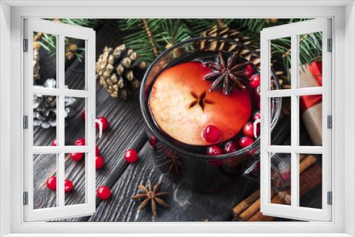 Fototapeta Naklejka Na Ścianę Okno 3D - glass mug of mulled spicy red wine with red berries and apple on wooden brown table with cookies, cinnamon sticks and cones