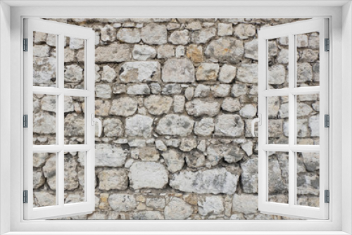 Fototapeta Naklejka Na Ścianę Okno 3D - Antique stone wall of an ancient fortress / castle, mainly white and light colored stone blocks of varying sizes and shapes, creating an individual pattern / texture.