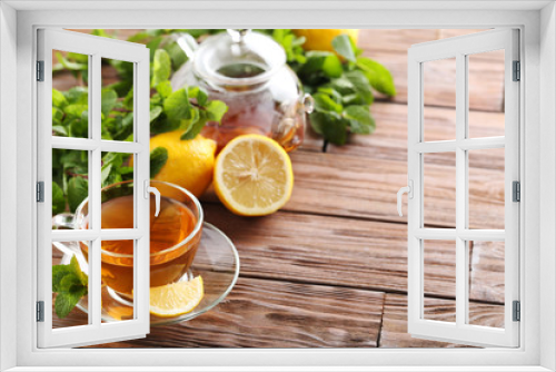 Fototapeta Naklejka Na Ścianę Okno 3D - Cup of tea with mint and lemon on brown wooden table