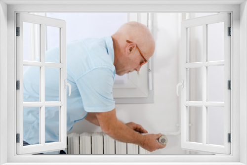 mature man changing temperature of radiator