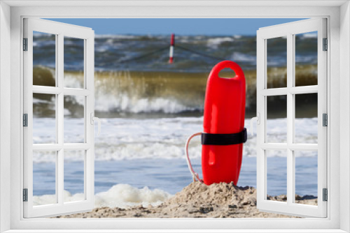 Fototapeta Naklejka Na Ścianę Okno 3D - Red flotation device (buoy) for water rescue at the beach. Windy day at the north sea.