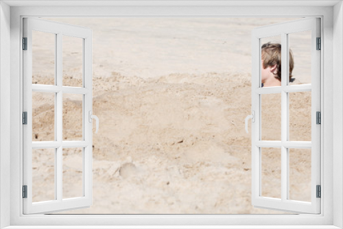 Fototapeta Naklejka Na Ścianę Okno 3D - Teen boy buried in the sand