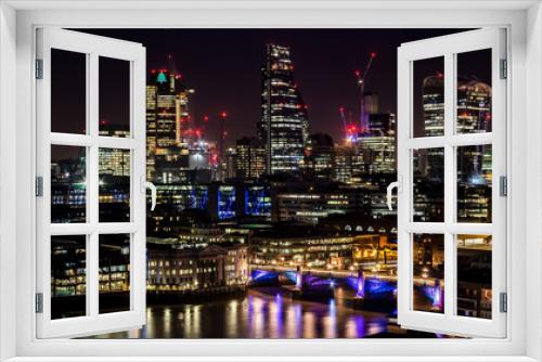 Fototapeta Naklejka Na Ścianę Okno 3D - Modern big city tall skyscrapers in the industrial business city at night. Capital of finances City of London at night. Long and curvy lights reflections in the river Thames.