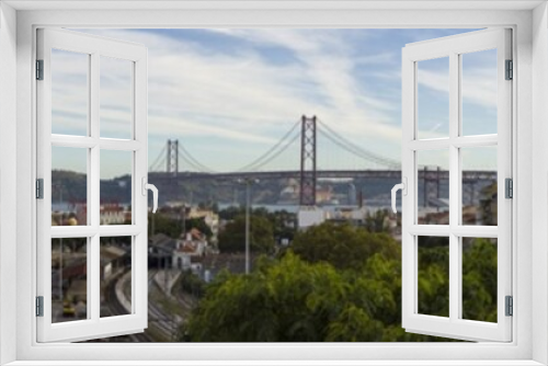 Fototapeta Naklejka Na Ścianę Okno 3D - panoramic view of Lisbon with the 25 de Abril Bridge, the Christ the King statue, railroad, numerous variegated houses and evening skyscape