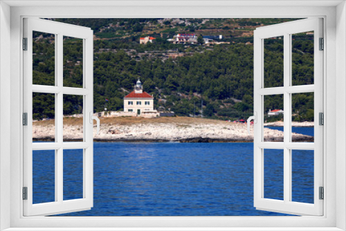 Fototapeta Naklejka Na Ścianę Okno 3D - Picturesque lighthouse on a small island in the Adriatic Sea. Near town Hvar, island Hvar, Croatia.

