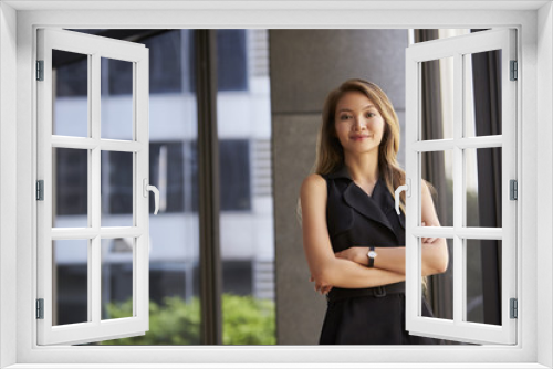 Young Asian businesswoman looking to camera, arms crossed