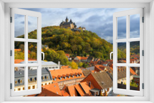 Fototapeta Naklejka Na Ścianę Okno 3D - A top view over Wernigerode town with a medievel castle crowning the hill top. Wide angle picture taken from the top of a town church on a cloudy Autumn day