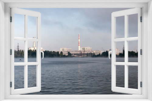 Fototapeta Naklejka Na Ścianę Okno 3D - Kursk Nuclear Power Plant reflected in a calm water surface.