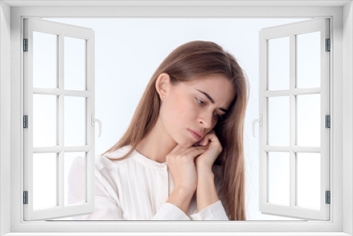 young girl tilted her head down and keeps hands near individuals is isolated on a white background